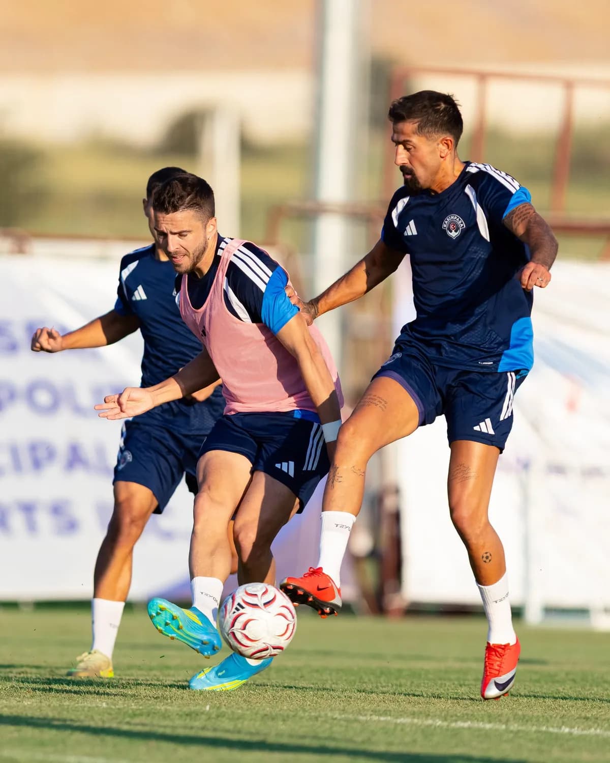 Kasımpaşa formalı iki futbolcu antrenmanda top mücadelesi veriyor